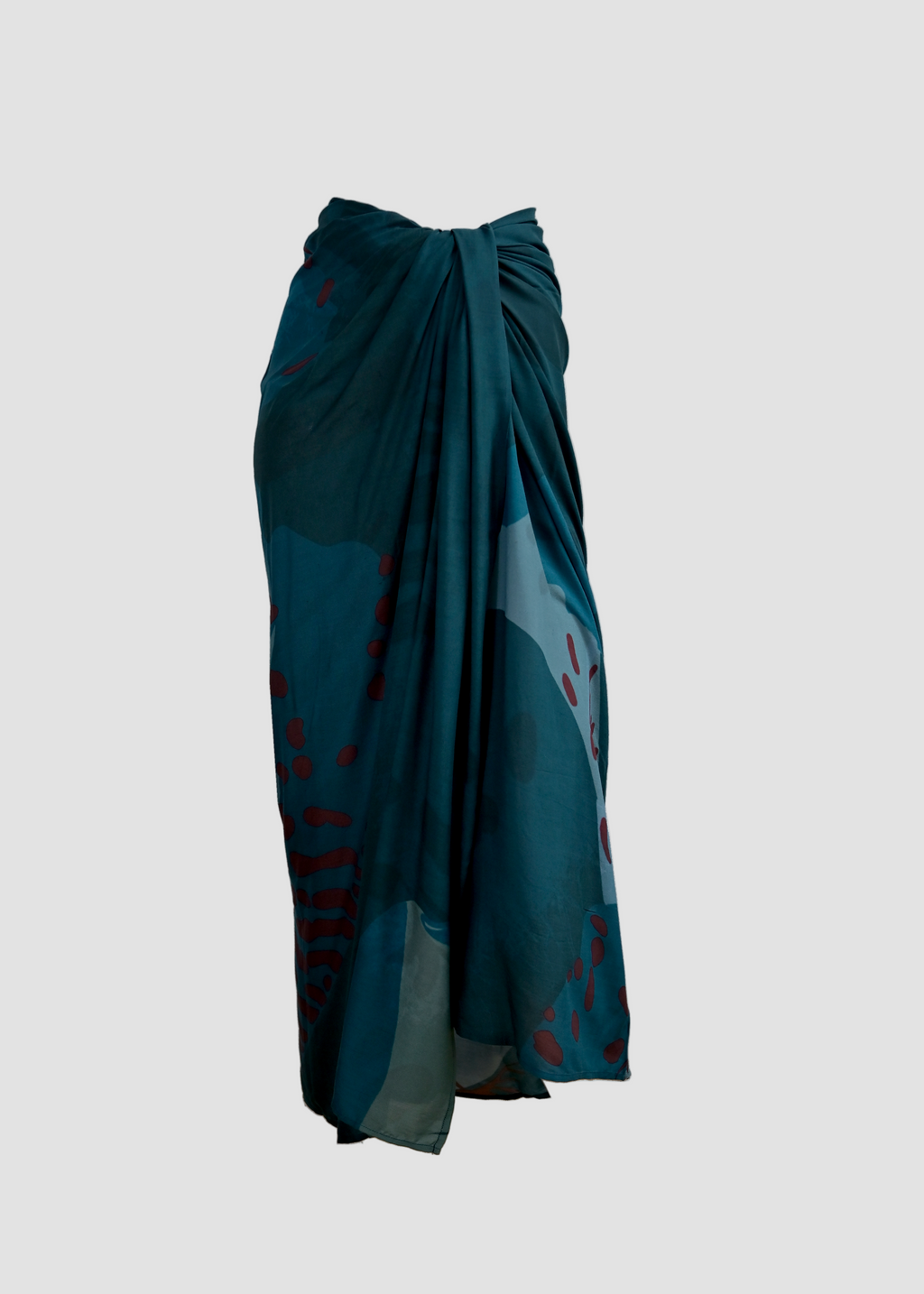 Teal wrap skirt with abstract patterns on a white background